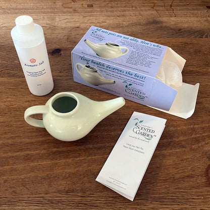 Neti Pot, Salt, and Instructions Included in the Scented Nasal Irrigation Kit on a Teak Tabletop